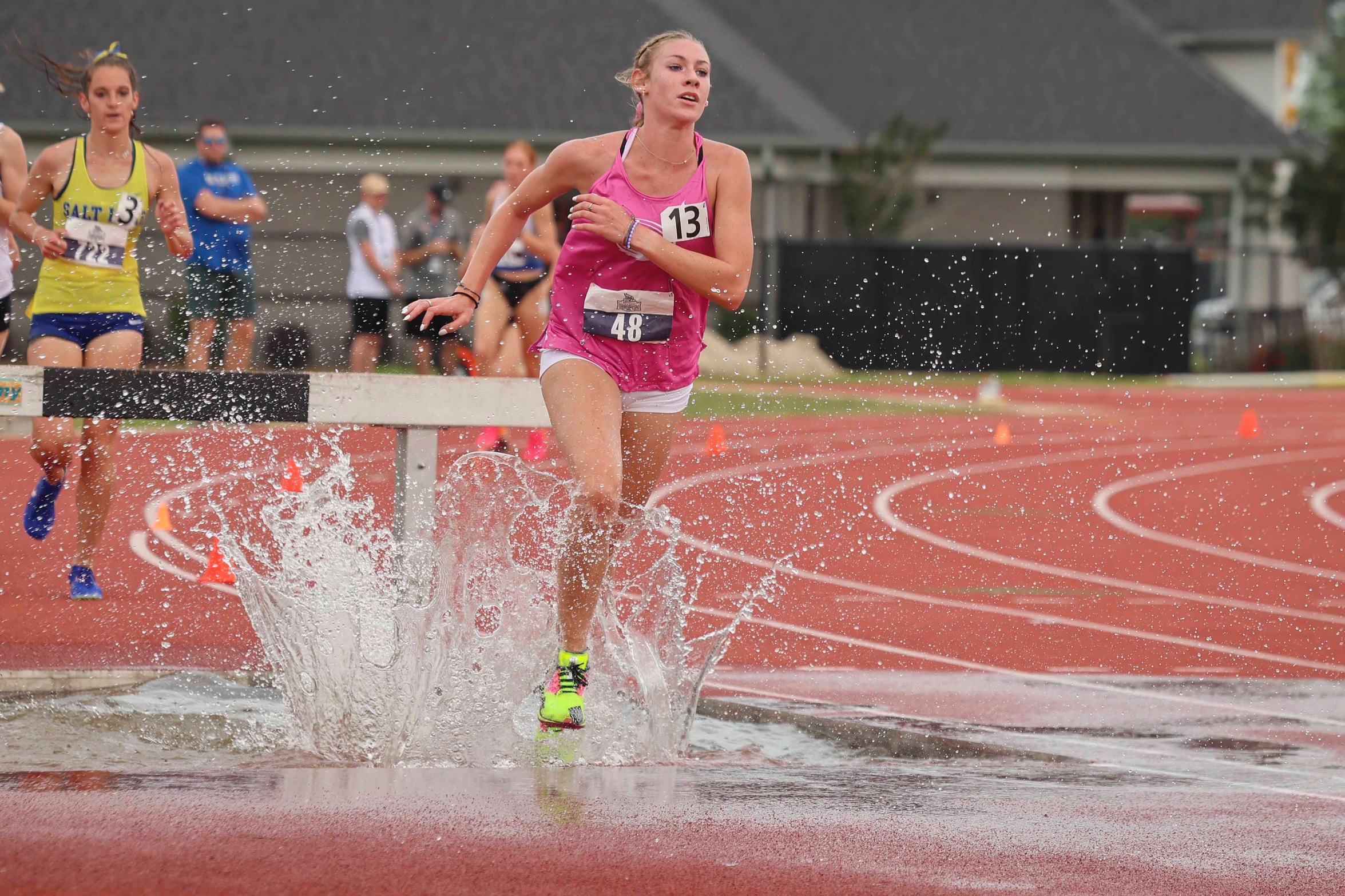 Heidi Grimmett splashes through a puddle in the women's 3000m steeplechase at the NJCAA D1 Outdoor Championships in West Monroe, Ala.